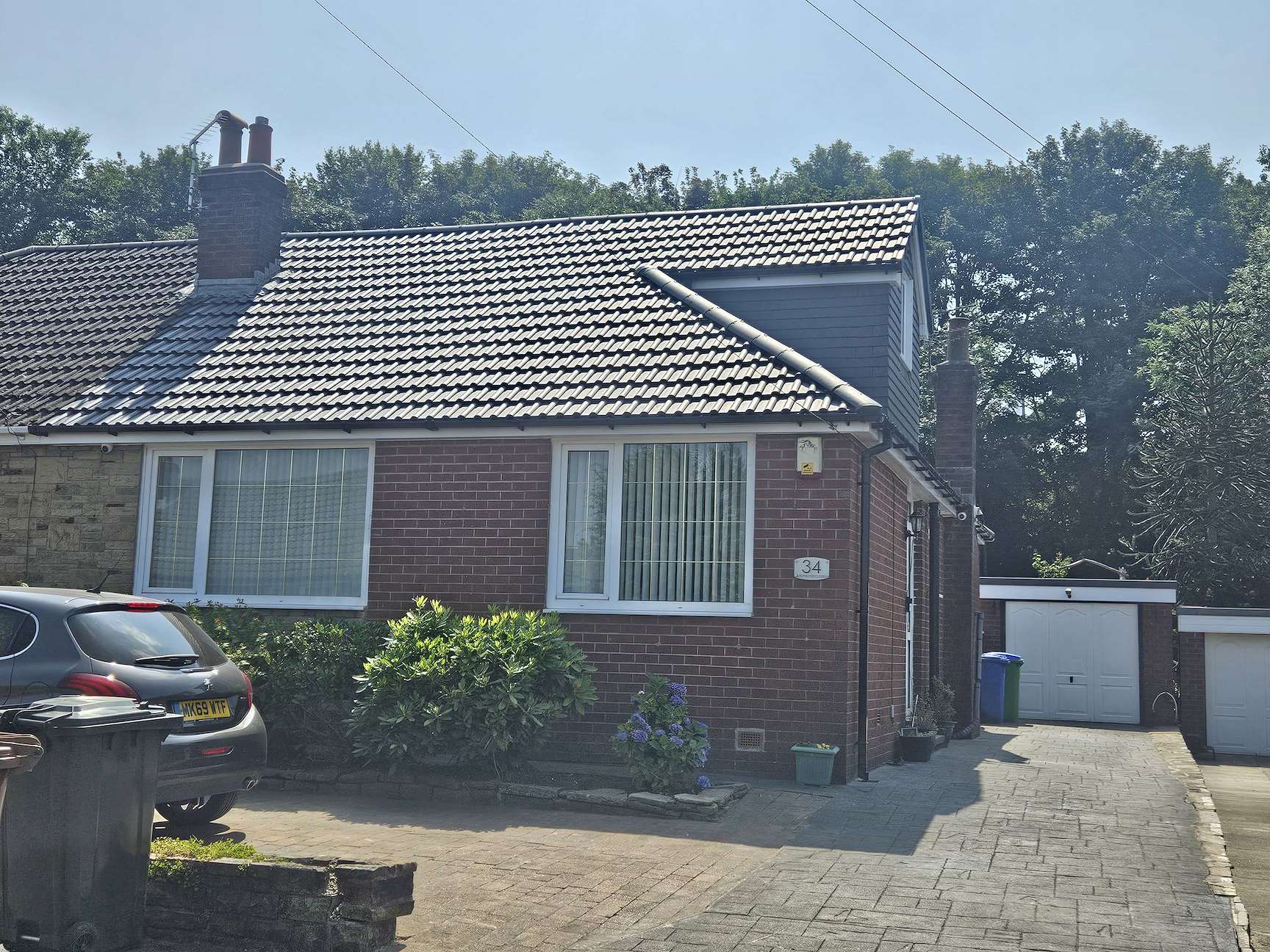 Finished dormer clad in slate-grey cladding with a newly tiled roof and white fascias