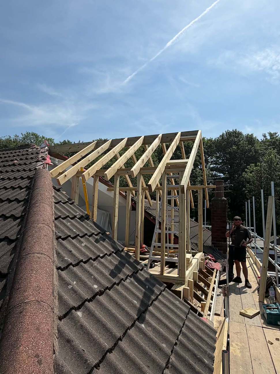 New pitched dormer roof structure framed in treated softwood timber on the opened roof