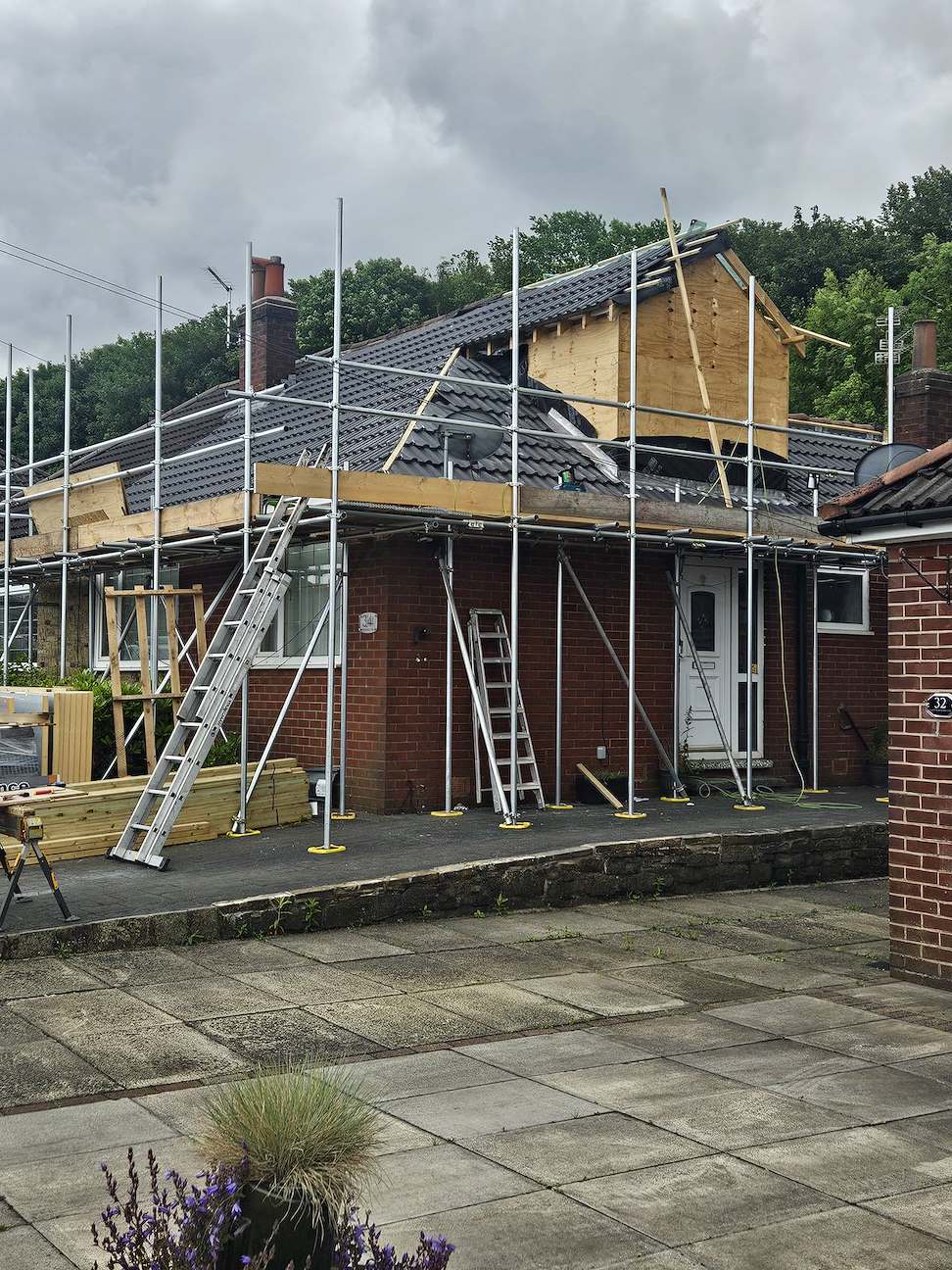Scaffolded dormer sheathed in board and made weather-tight before external finishing